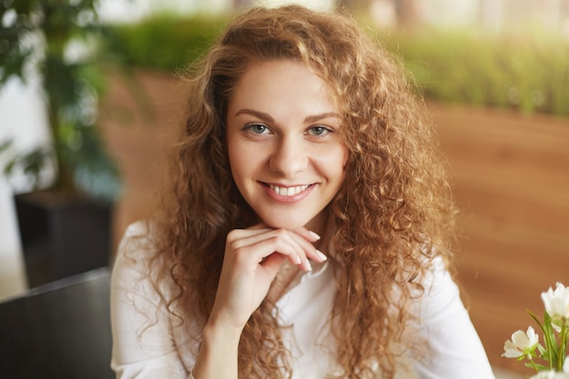 La bella giovane femmina attraente positiva ha un aspetto accattivante