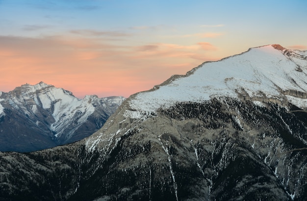 La bella neve ha ricoperto le montagne contro il cielo crepuscolare al parco nazionale di Banff in Alberta, Canada.