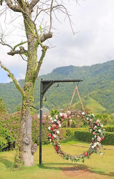 La bella oscillazione del cesto delle nozze decorate con le rose variopinte fiorisce nel natu