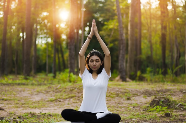 La bella ragazza asiatica sta meditando.