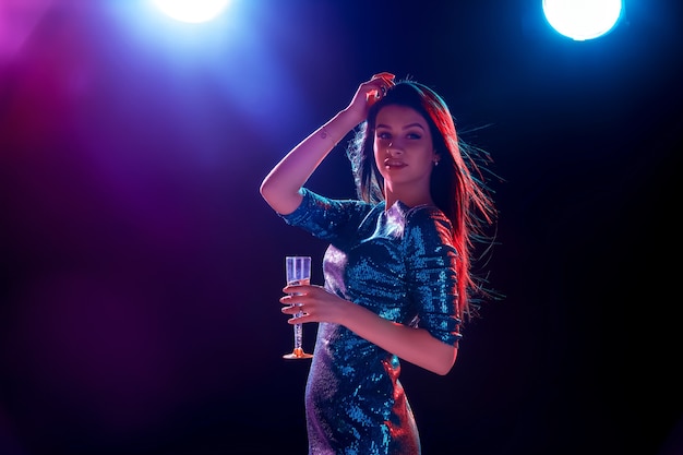 La bella ragazza che balla alla festa bevendo champagne