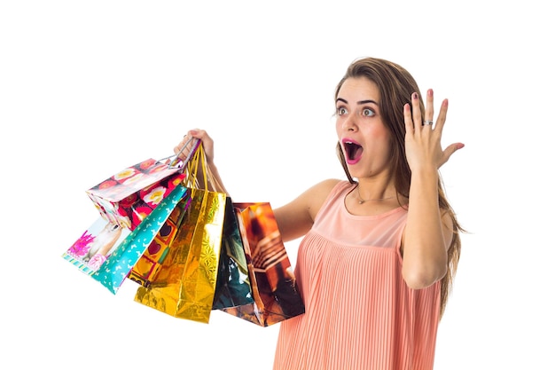 La bella ragazza con grande sorpresa tiene in mano molti pacchetti colorati diversi con il primo piano degli acquisti