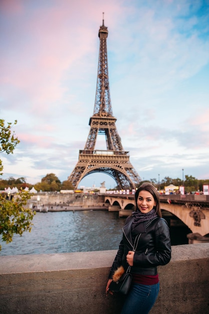 La bella ragazza davanti alla ragazza della torre eiffel sta sorridendo e gioendo foto d'autunno