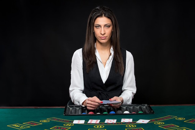 La bella ragazza del dealer dietro un tavolo da poker