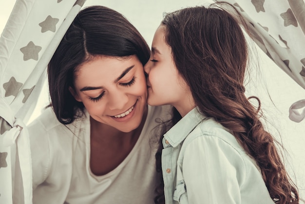 La bella ragazza della scuola e sua madre stanno parlando e sorridendo.