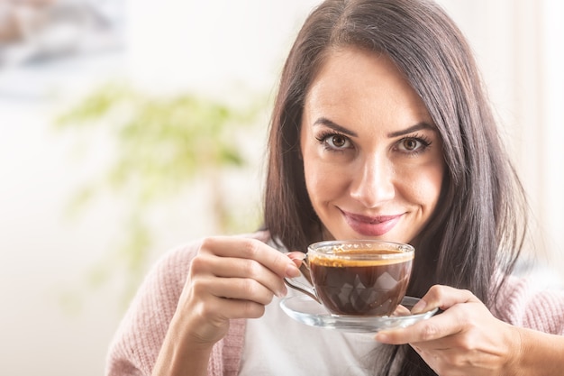 La bella ragazza gode dell'odore del caffè appena fatto.