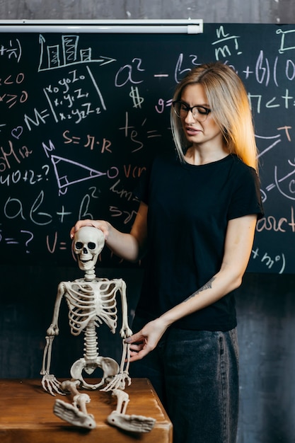 La bella ragazza impara la biologia in una classe