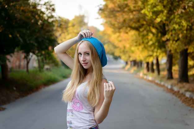 La bella ragazza in un berretto blu a passeggio