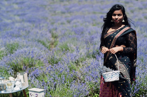 La bella ragazza indiana indossa il vestito tradizionale dall'India di saree nel campo viola della lavanda.