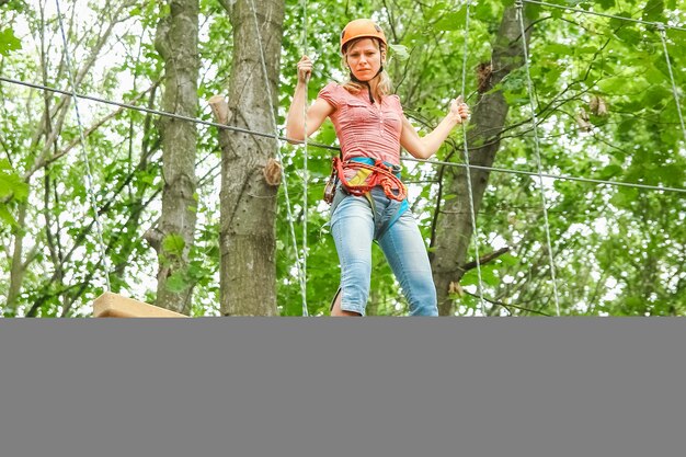 La bella ragazza nel parco sulle corde realizza all'aperto