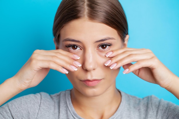 La bella ragazza sente un forte dolore intorno agli occhi