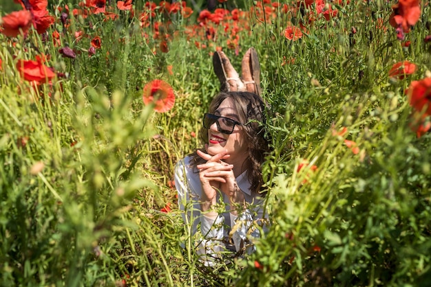 La bella ragazza si trova in un campo di papaveri rossi. uno stile di vita sano. estate