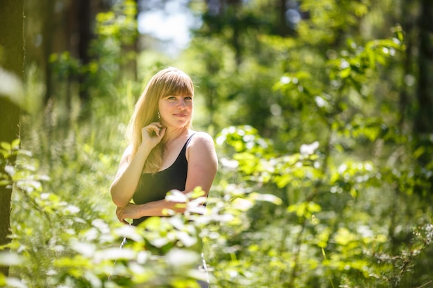 La bella ragazza sta nel boschetto della foresta