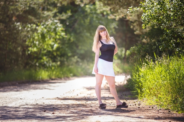 La bella ragazza sta nel boschetto della foresta