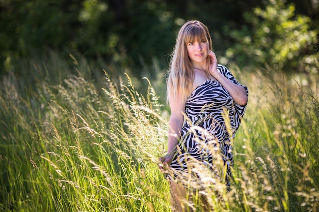 La bella ragazza sta nel boschetto della foresta