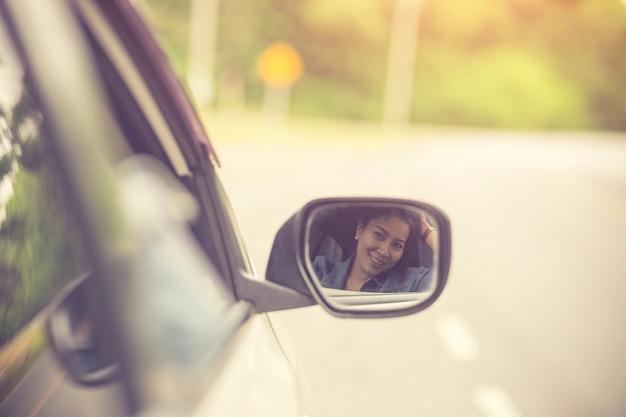 La bella ragazza sta sorridendo mentre guidava un&#39;automobile