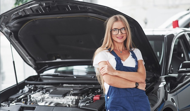 La bella riparatrice bionda sta facendo il suo lavoro. All'interno al negozio di auto