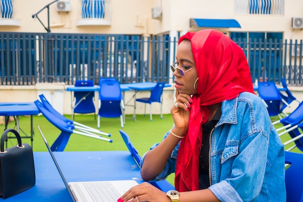 La bella signora africana si concentra seriamente su ciò che ha visto sul suo laptop