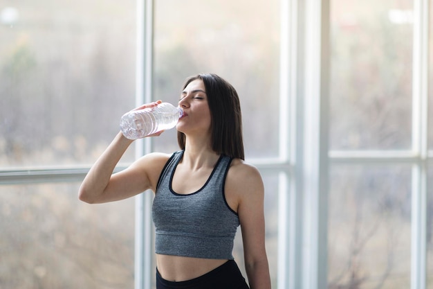 La bella sportiva turca sta bevendo acqua dopo la sessione di allenamento