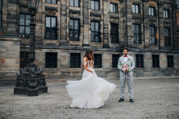 La bella sposa del ritratto sta ballando per lo sposo e sta girando indietro all'aperto.