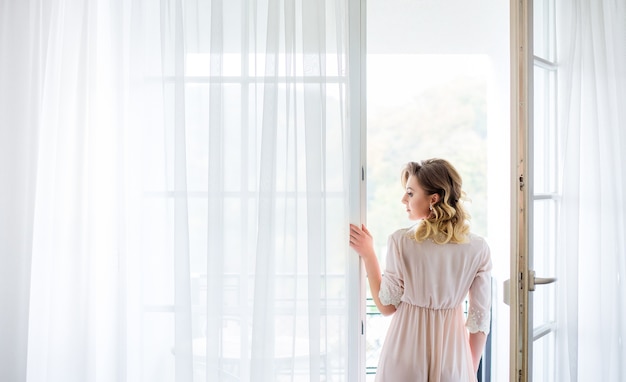 La bella sposa si trova vicino al balcone