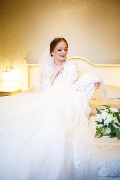 La bella sposa veste il suo abito da sposa bianco