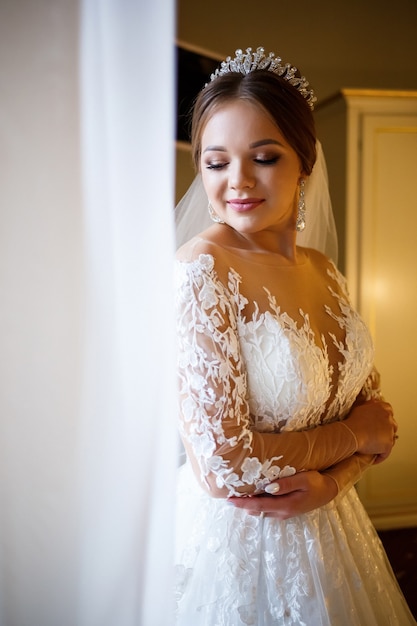 La bella sposa veste il suo abito da sposa bianco