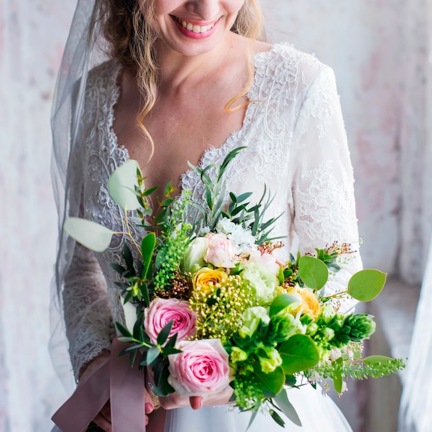 La bella tenuta attraente della sposa fiorisce il mazzo