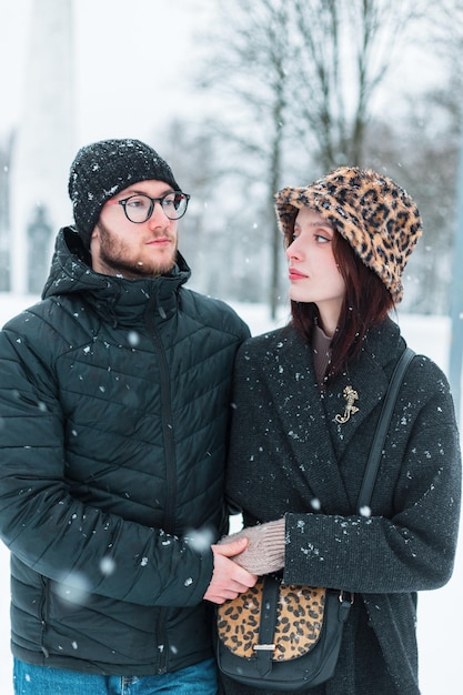 La bellezza della moda giovane coppia di amanti in inverno abiti alla moda cammina insieme in un giorno di inverno innevato all'aperto donna bella e uomo bello