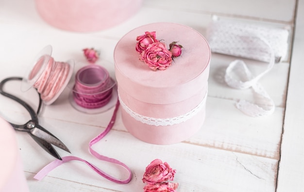 La bellissima confezione regalo rotonda rosa è decorata con rose ristrette