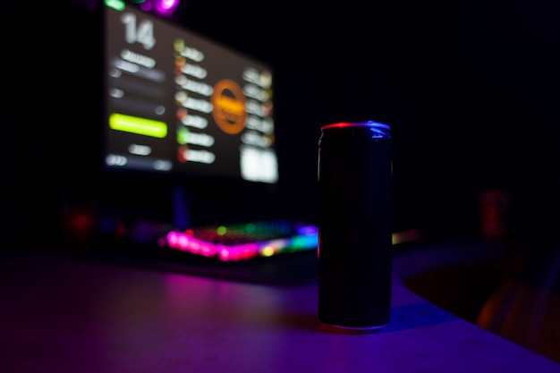 La bevanda energetica si trova su un tavolo da gioco vicino a un computer un primo piano della bevanda di un giocatore
