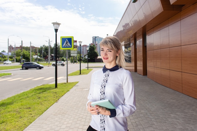 La bionda con un taccuino per strada