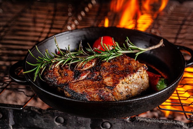 La bistecca di agnello viene fritta sul fuoco in una padella di ghisa