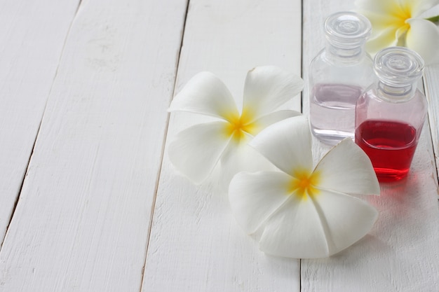 La bottiglia di Plumeria e Gel è posta su un pavimento di legno bianco.