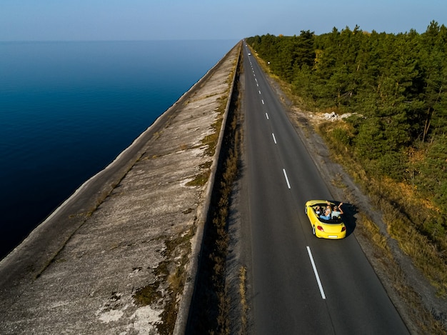 La cabriolet gialla che guida sull'autostrada costiera