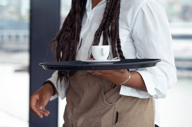 La cameriera sta portando il caffè.