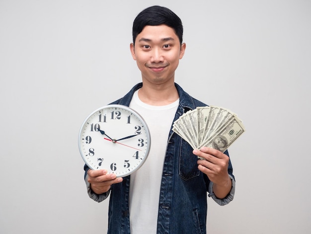 La camicia dei jeans dell'uomo positivo tiene i soldi con il sorriso gentile dell'orologio isolato