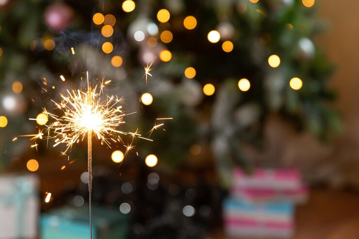 La candela scintillante delle stelle filanti di Natale brucia nella decorazione dell'illuminazione di natale del fondo dell'albero di natale a