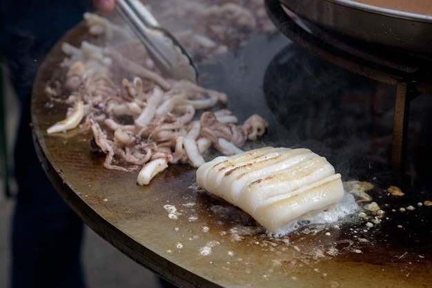 La carne di polpo viene preparata al festival del cibo di strada con fumo e fuoco