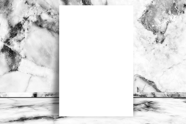 La carta in bianco bianca deride su sul fondo di marmo bianco di struttura della stanza