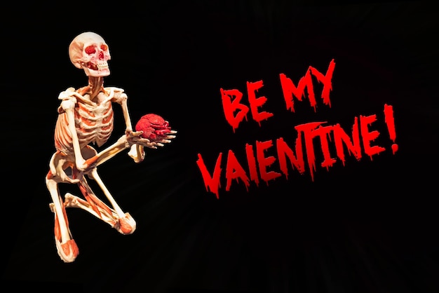 La carta spaventosa sii il mio scheletro di San Valentino mantiene il suo cuore isolato su uno sfondo nero vita amore e dea...