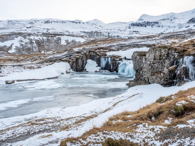 La cascata di Kirkjufellfoss con la sua vista circostante congela l'acqua, il punto di riferimento più popolare in Islanda