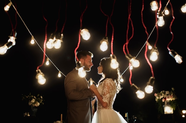 La cerimonia nuziale notturna. Sposa e sposo che si guardano sullo sfondo