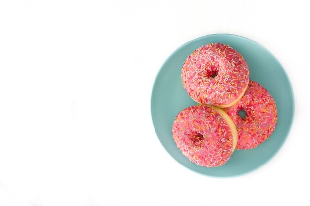 La ciambella glassata rosa con variopinto spruzza isolato su bianco