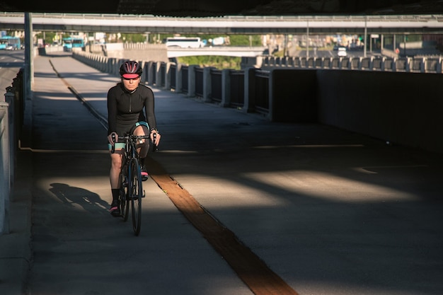 La ciclista sportiva corre in città al mattino