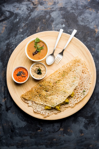 La cipolla rava masala dosa è una colazione istantanea dell'India meridionale servita con chutney e sambar su uno sfondo lunatico. messa a fuoco selettiva
