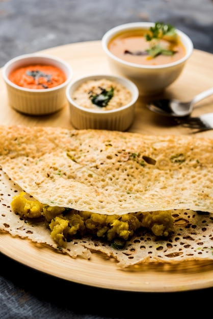 La cipolla rava masala dosa è una colazione istantanea dell'India meridionale servita con chutney e sambar su uno sfondo lunatico. messa a fuoco selettiva