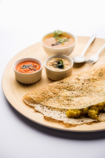 La cipolla rava masala dosa è una colazione istantanea dell'India meridionale servita con chutney e sambar su uno sfondo lunatico. messa a fuoco selettiva