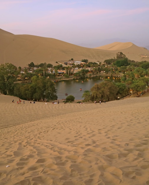 La città di oasi di Huacachina vista dalla duna di sabbia al tramonto, regione di Ica, Perù