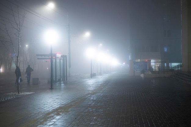 La città notturna con le condizioni meteorologiche nebbiose, il mistero all'aperto, la paura mentre si cammina da soli